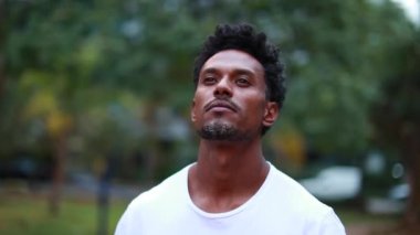 Confident african american man standing outdoors looking at sky feeling hopeful