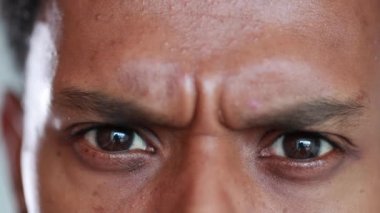 Suspicious eyes closeup. Skeptical African American macro close-up eye being paranoid