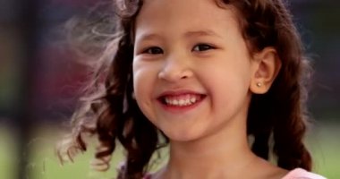 Happy little girl child smiling to camera with joy