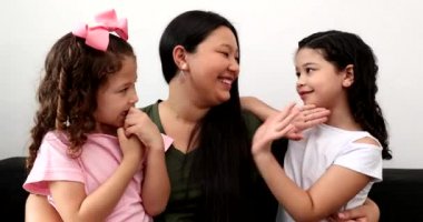 Asian mother telling good news to daughters, japanese mom with mixed race little girls love
