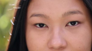 Young Asian woman close-up eyes and face looking at camera