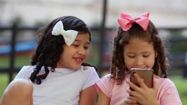 Two Children Little Girls Looking Cellphone Outdoors — Video