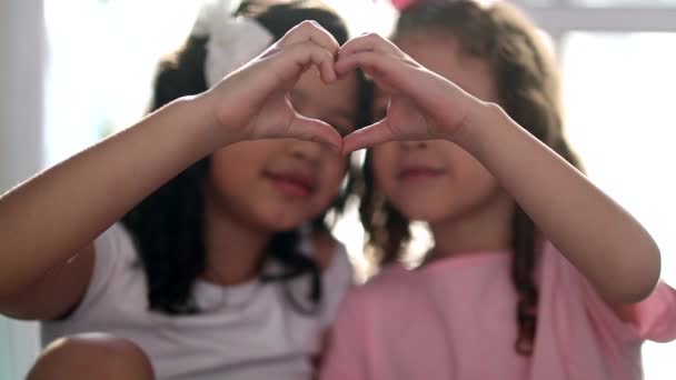 Two Little Sisters Making Heart Sign Together — Stockvideo