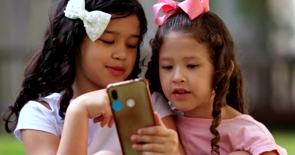 Діти Дивляться Мобільний Пристрій Дві Маленькі Дівчата Переглядають Інтернет Смартфоні — стокове відео