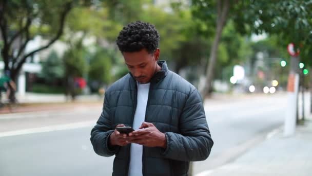 Людина Ходить Перевірці Смартфона Тротуарі Випадковий Чорний Чоловік Дивиться Мобільний — стокове відео
