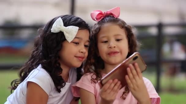 Two Cute Hispanic Little Girls Holding Cellphone Interaction — Stockvideo