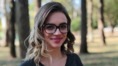 Feminist Girl wearing glasses looking directly to camera smiling