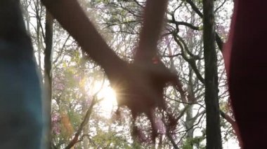 Close-up of two LGBT Lovers Joining Hands in SLOW-MOTION with sun flare