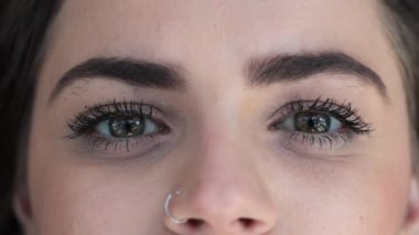 Macro of green eyes opening and closing. Dreamy Pretty eyes looking to camera