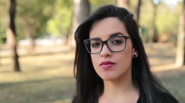 Young brunette woman wearing feminist glasses with a serious look expression on face looking camera