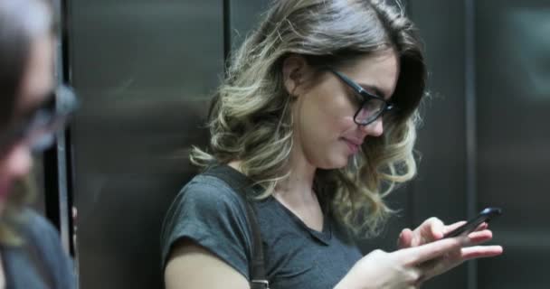 Случайная Откровенная Молодая Женщина Проверяет Свой Телефон Лифте — стоковое видео