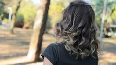 Girl turns around looks to camera smiling while walking backwards