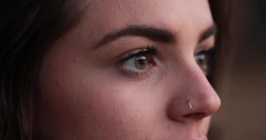Young woman close-up of girl face with green eyes looking at horizon thinking about life in meditative contemplation