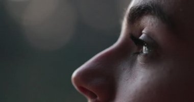 Young woman face opening and closing eyes. Girl meditating and in contemplation looking up to the sky with hope and faith
