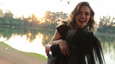 Girl piggy backing on friend back during sunset golden hour. Friends piggy back