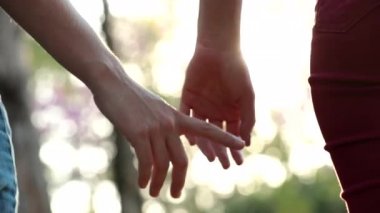 Close-up of hands joining together with sunlight flare in the background