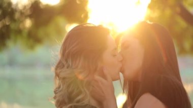 Authentic LGBT female lesbian couple kissing each other in slow-motion. Women kiss each other