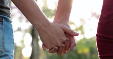 Disjoining hands, breaking the chain from hands held together in the sunlight