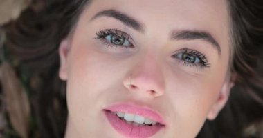 Girl face looking to camera closes eye. Woman face with green eyes starring at camera closing eyes