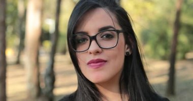 Hispanic woman wearing glasses looking to camera. Smart Latina girl