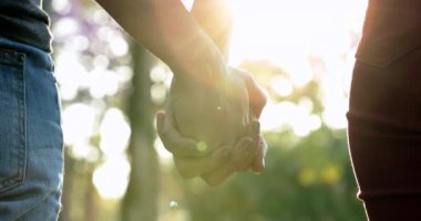 Hands held together with sunlight flare in the background