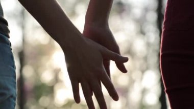 Close-up of two LGBT Lovers Joining Hands in SLOW-MOTION with sun flare