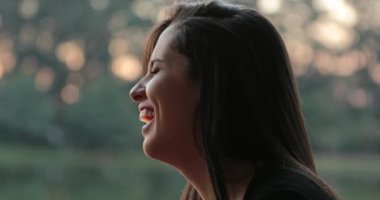 Candid profiles of friends speaking outdoors at the park, authentic real life laugh and smile