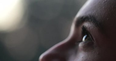 Young woman face opening eyes in meditation and contemplation loooking up at the sky with hope and faith