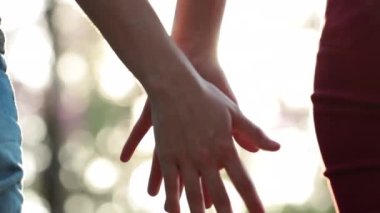 Close-up of two LGBT Lovers Joining Hands in SLOW-MOTION with sun flare