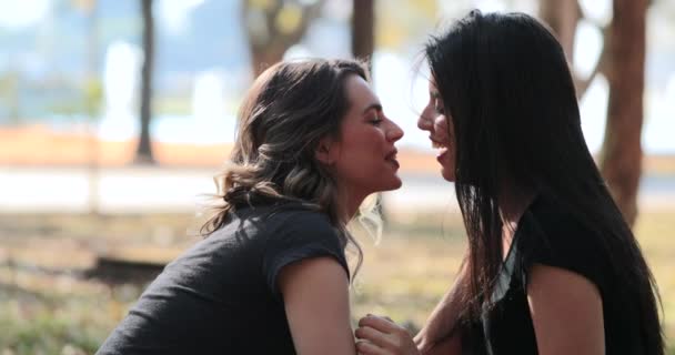 Lesbian cuple kissing each. LGBT Girlfriend kisses female mate at the park