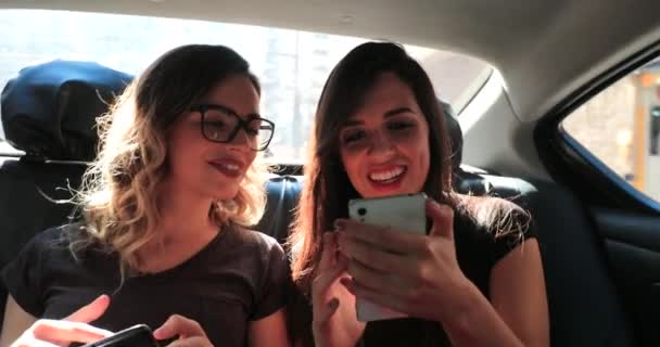 Friends Looking Cellphones Back Seat Taxi Cab Gossiping Browsing Internet — Stockvideo
