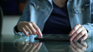 Hand scrolling online content on tablet screen. Closeup female hands touching modern digital device browsing internet online