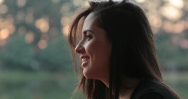 Candid profiles of friends speaking outdoors at the park