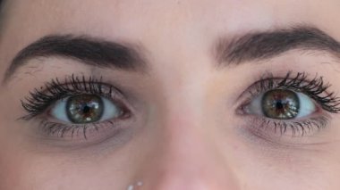 Macro of green eyes opening. Pretty eyes looking to camera smiling