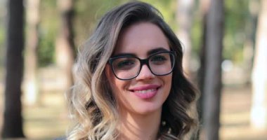 Pretty woman wearing glasses opening eyes and looking to camera smiling. Smart woman