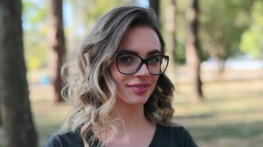 Smart girl with glasses looking directly to camera smiling