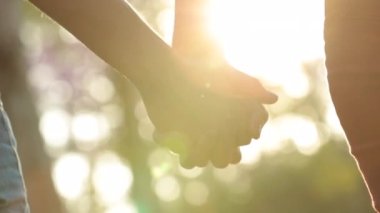 Hands held together with sunlight flare shining in the background
