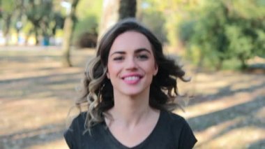 Girl walking towards camera smiling at the park
