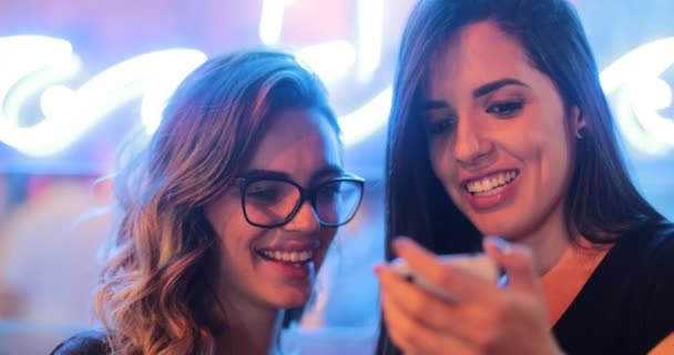 Δύο Κορίτσια Ελέγχουν Smartphone Νύχτα Νεαρές Γυναίκες Πρωταγωνιστούν Στην Οθόνη — Αρχείο Βίντεο