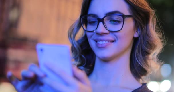 Молода Жінка Тримає Смартфон Ввечері Поруч Рухомим Трафіком — стокове відео