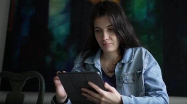 Woman using tablet device at home. Person holding modern technology browsing internet online