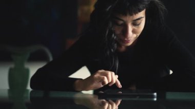 Woman browsing internet on digital tablet device at home. Person searching online touching screen scrolling