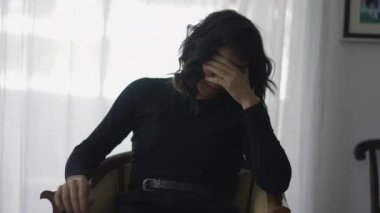 Woman covering face in shame suffering from emotional pain