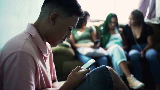 Unge Man Tittar Telefonskärmen Förgrunden Tre Kvinnliga Vänner Bakgrunden — Stockvideo