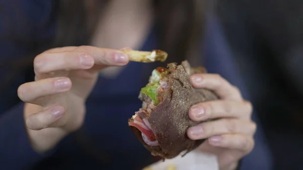 Closeup hands holding burger. Cheese hamburger