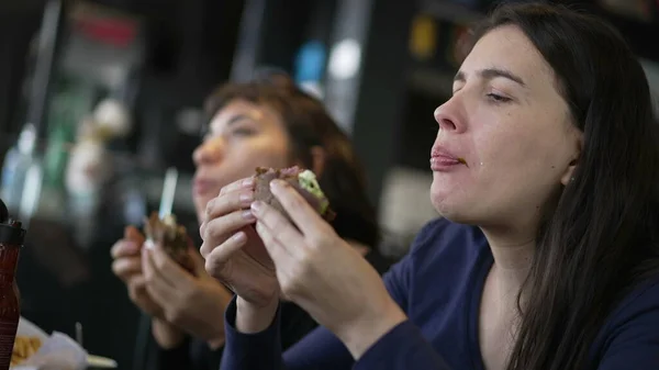 Two Young Women Eating Hamburgers People Restaurant Taking Bite Burgers — Stock Photo, Image