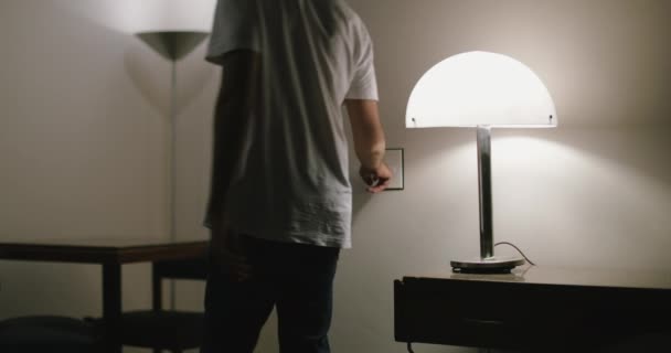 若い男が電気を消して家を出る — ストック動画