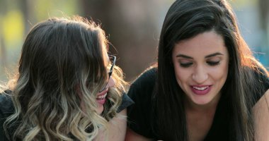 Girl surprise astonished reaction. Hispanic woman expression and happy. Friends lying on grass in the sunlight chatting