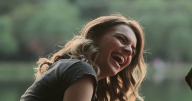 Kız konuşma arkadaşı yla konuşurken, burts arkadaş şaka yüksek sesle gülüyor. Gerçek hayat otantik gülümseme ve spontan kahkaha