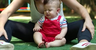 Upset displeased baby boy with mom outside complaining